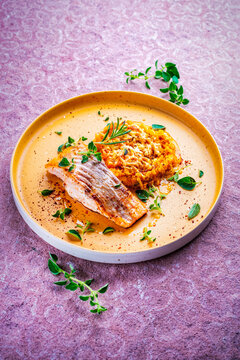 Fried salmon fish fillet with pumpkin and sweet potato rosti gratin served as close-up on a design plate