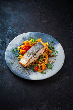 Fried salmon fish fillet with pumpkin and sweet potato rosti gratin served as close-up on a design plate