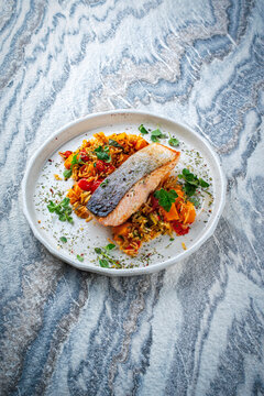 Fried salmon fish fillet with pumpkin and sweet potato rosti gratin served as close-up on a design plate