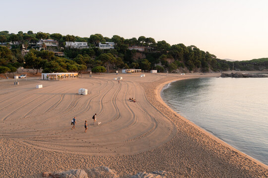 Familia por la playa de Sa Conca al amanecer en S'Agar&oacute;, Costa Brava
