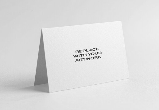Paper tent card mockup standing upright on a white surface, realistic stationery presentation with text placeholder, graphic design template for business cards, brochures, or invitations