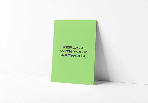 Vertical poster mockup standing upright on a white surface against plain wall, clean minimalist studio presentation for graphic design or branding display, template print digital artwork