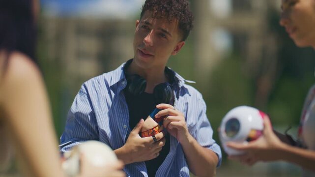 Young school friends engage in an outdoor study session with anatomical models of the brain and eye. These students are learning about human biology in a casual environment.
