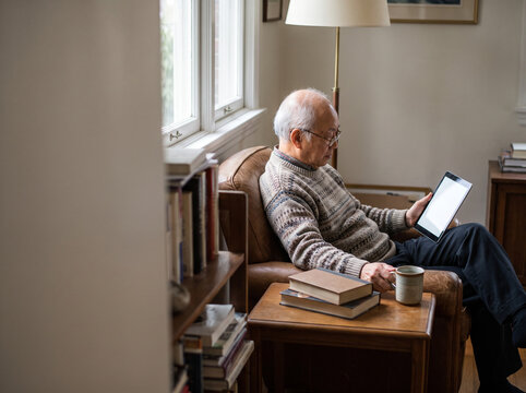 Older Man Reading an E-Book at Home