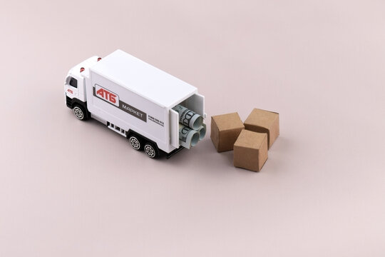 White toy truck with ATB emblem with boxes on light background, space for text.