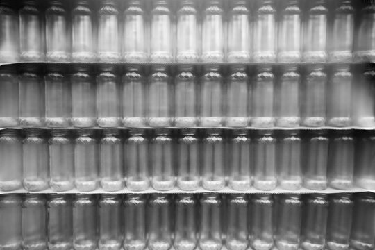 Black and White Pattern of Packaged Glass Bottles. Motion blur is used for dynamics.
