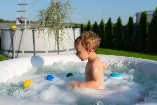 Boy enjoying bubbly water in backyard jacuzzi pool