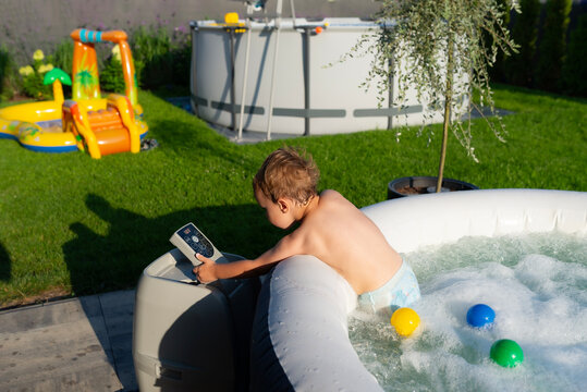 Young boy playing with bubbles in inflatable spa
