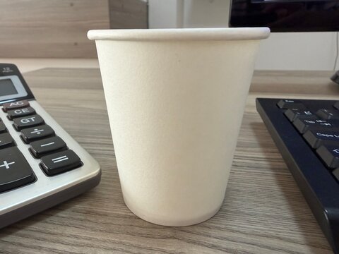 An empty paper cup on an office desk