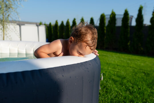 Toddler boy playing in inflatable outdoor hot tub