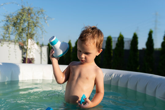 Young boy playing in inflatable pool during summer