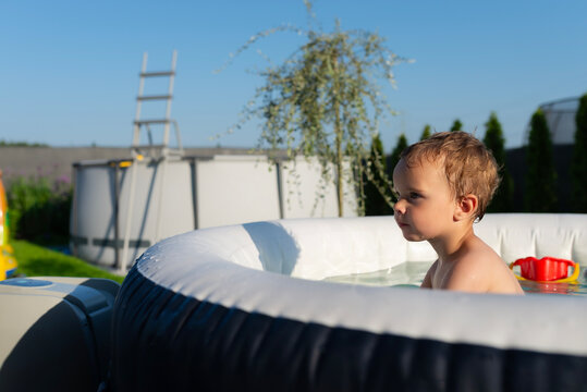 Toddler boy enjoying summer fun in inflatable jacuzzi