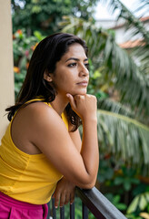 Fototapeta premium Thoughtful woman on balcony contemplation and reflection mental well being and mindfulness looking away with pensive expression