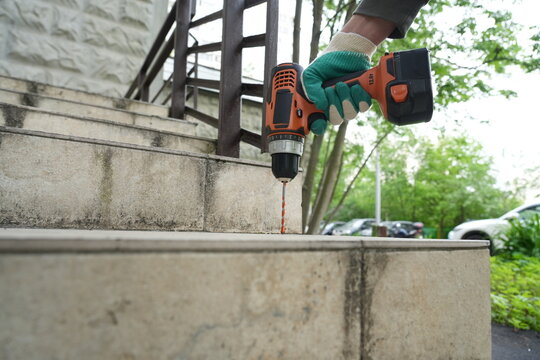 Drilling concrete stairs outdoors with cordless power tool