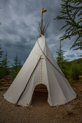 White teepee tent standing in natural forest environment © Georges_Flayols