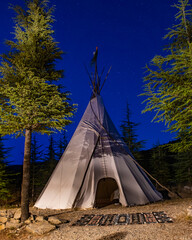 Tipi tent under starry night sky in forest © Georges_Flayols