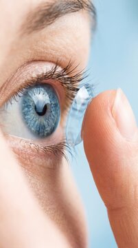 Inserting a corrective contact lens. Man with blue eyes