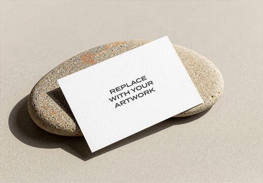 Business card mockup with textured paper surface resting on a speckled stone neutral background, realistic stationery branding presentation, template for graphic design and print
