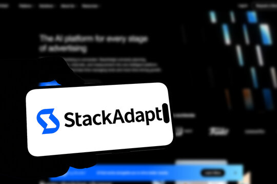 Kiel, Germany - 08-19-2026: Smartphone displaying Canadian advertising technology company StackAdapt logo in front of companys webpage