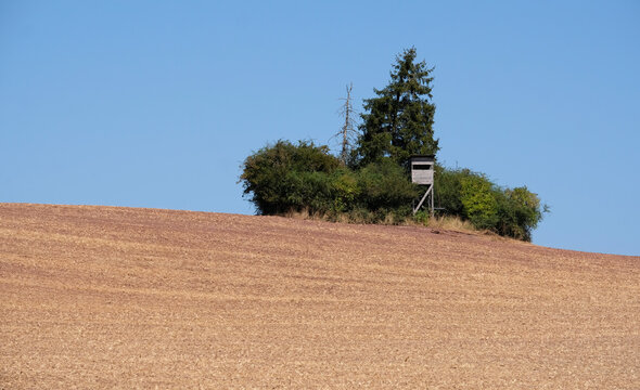 Raised hide next to some trees and a dry field in Thuringia, Germany