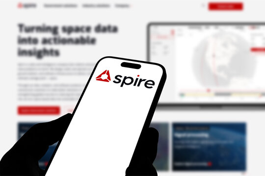 Kiel, Germany - 08-19-2026: Smartphone displaying US space data and analytics company Spire Global logo in front of companys webpage