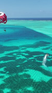 Parasailing In San Andres Caribbean Island Colombia. Tourists Parasailing Over A Tropical Ocean On A Sunny Day. Seaside Beach. Tropical Skyline. San Andres Caribbean Island.
