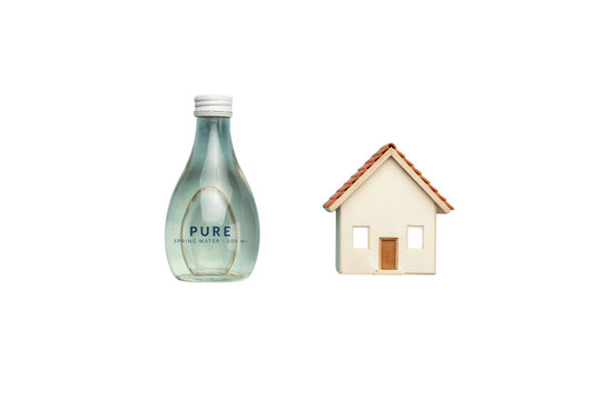 Conceptual Image of a Glass Water Bottle and a Miniature Model House Representing Sustainable Living and Water Security