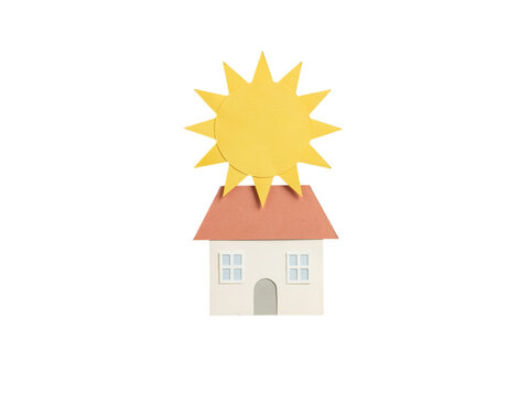 Paper craft house with bright yellow sun on white background representing solar energy eco home and real estate