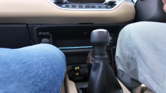 Driver hand shifting manual car gear stick inside vehicle interior in Delhi NCR India