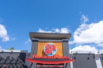 Fototapeta premium Toronto, ON, Canada - August 17, 2026: Closeup exterior storefront signage of a Boston Pizza restaurant and sports bar on the building in Toronto, ON, Canada. 