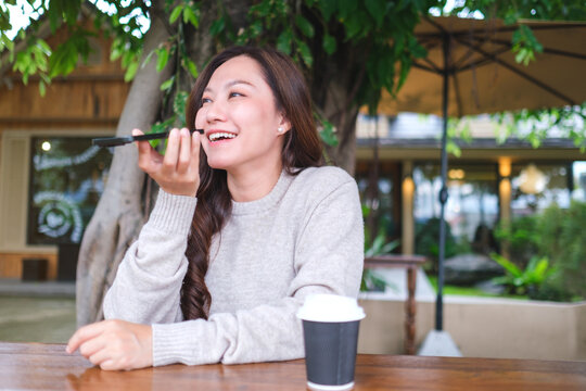 A woman holding smart phone and using voice messaging, talking with ai assistant for Artificial intelligence concept