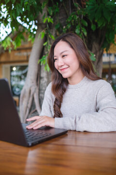 Vertical portrait image of a woman working on laptop computer