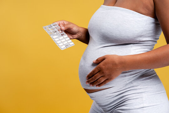 Pregnant woman taking prenatal vitamins for healthy pregnancy