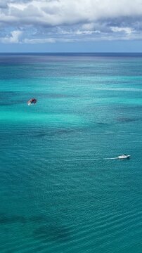 Parasailing In Providenciales Turks And Caicos United Kingdom. Thrilling Adventure With Speedboat Paragliding In Turquoise Ocean. Summer Backgrounds. Bay Water Landscape.