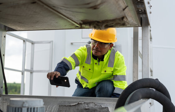 Maintenance technician using smartphone camera to inspect industrial equipment condition, representing digital documentation, machinery diagnostics, preventive maintenance and technical field service.