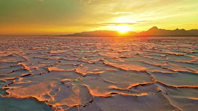 Golden sunset light illuminating distinctive hexagonal salt crust patterns across the Bonneville Salt Flats in Utah