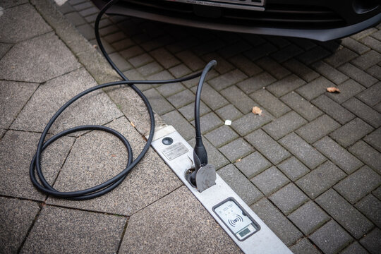 Ein E-Auto wird an einem Ladebordstein auf der K&Ouml; mit einem Kabel aufgeladen, D&uuml;sseldorf, Deutschland
