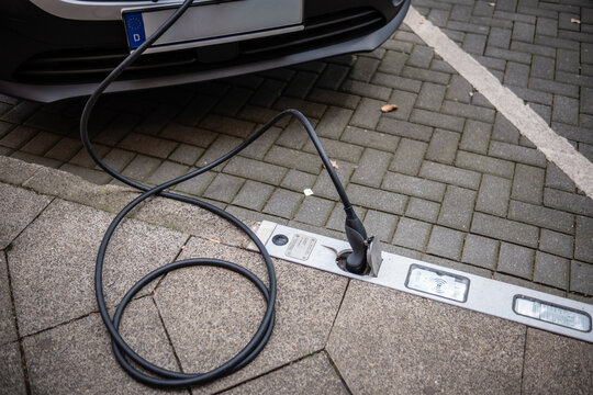 Ein E-Auto wird an einem Ladebordstein auf der K&Ouml; mit einem Kabel aufgeladen, D&uuml;sseldorf, Deutschland