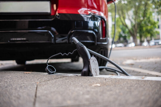 Ein E-Auto wird an einem Ladebordstein auf der K&Ouml; mit einem Kabel aufgeladen, D&uuml;sseldorf, Deutschland