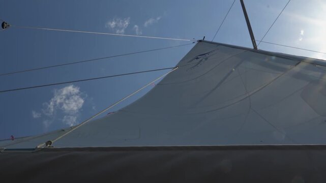 Sailboat main sail catching wind on a sunny day