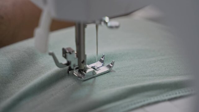 Man Stitching Clothes Using an Electric Sewing Machine.