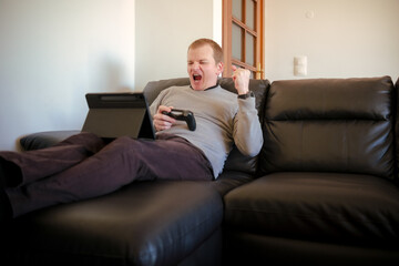 Man winning video game at home with tablet © Digito  Pitoresco