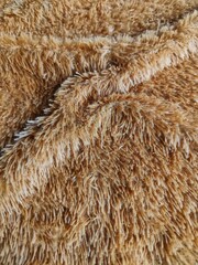 Close-up texture of soft light brown plush faux fur fabric, detailed macro background for design projects. © Mas