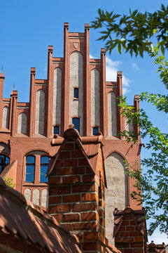 Red brick historic architecture in Torun, Poland featuring neogothic building facade and clear blue sky.