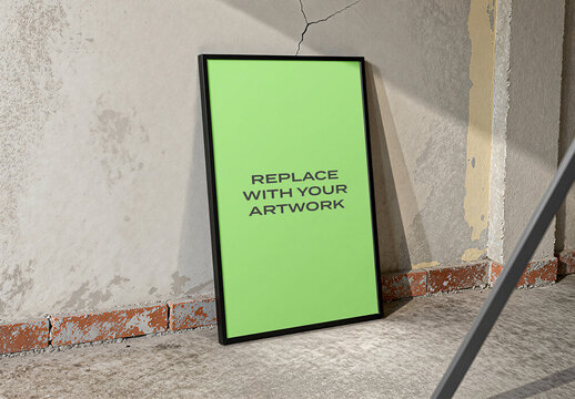 Vertical framed poster mockup leaning against a cracked concrete wall in an industrial interior, realistic art presentation with natural light and shadow, template for graphic design print display