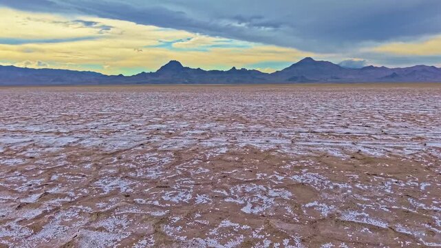 Aerial view of golden sunset light highlighting hexagonal crust patterns across Bonneville Salt Flats in Utah