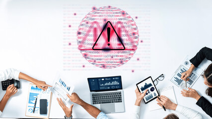 Obraz na płótnie Canvas A diverse team works together in a modern office setting, analyzing data and discussing strategies while a warning symbol signifies important security concerns. Gantry