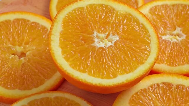 Sliced orange rotation on wooden plate.
