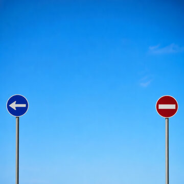 Two contrasting road signs against a bright blue sky, illustrating choices, direction, and obstacles