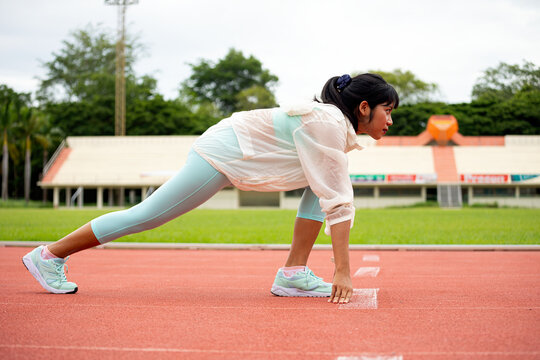 Woman athlete stretching on running track before workout, focused on fitness, exercise, training, flexibility, warmup, sport and healthy outdoor performance